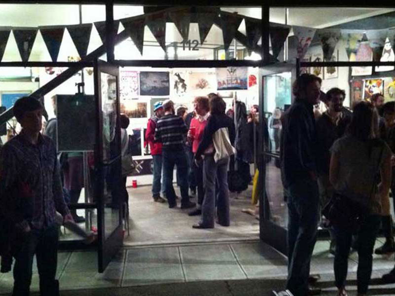 Night exterior of 112 PrintWorks, crowd spilling out the door